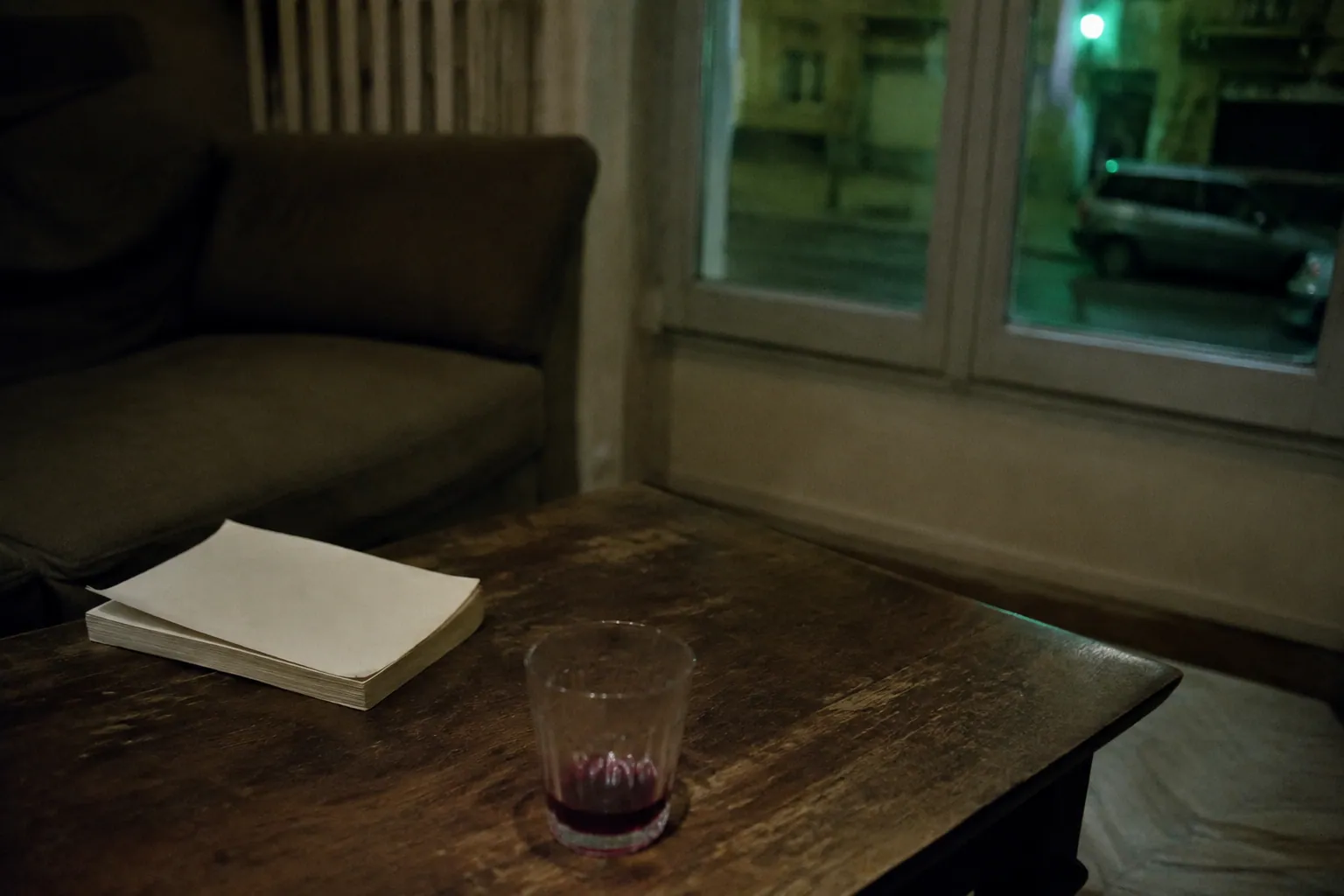 夜のパリの小さな部屋、読みかけの本と飲み残した赤ワインの一杯