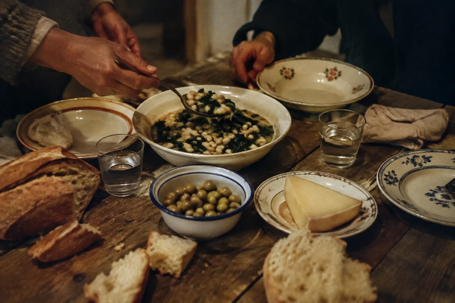 パンと豆の煮込みとオリーブを分け合う農家の食卓