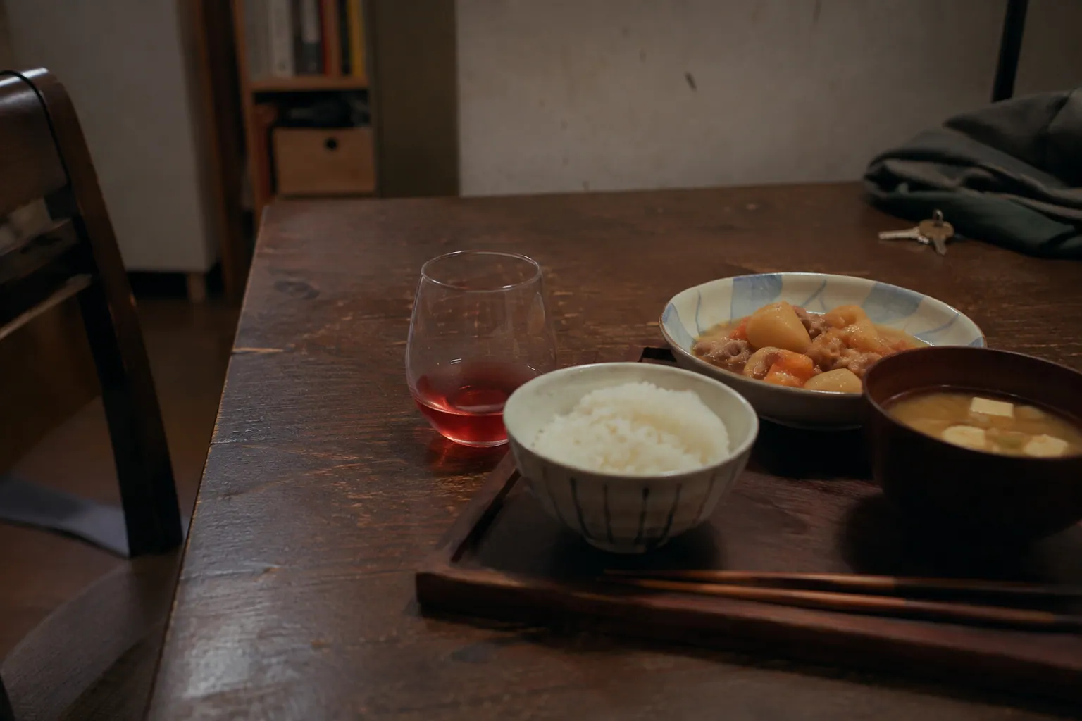 月曜夜の木の食卓に並ぶ肉じゃがと味噌汁、小さな一杯